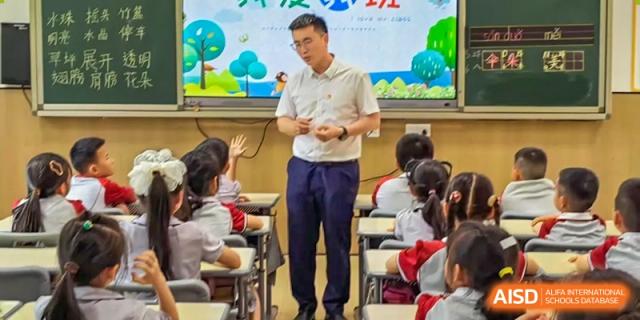 A teacher giving a lecture to a group of students in a classroom at Weiming School Chengdu Qingbaijiang.