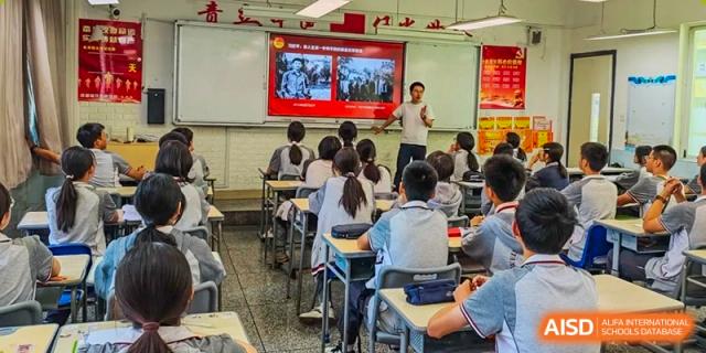 Weiming School Chengdu Qingbaijiang students watching a lecture on a large screen in a classroom.