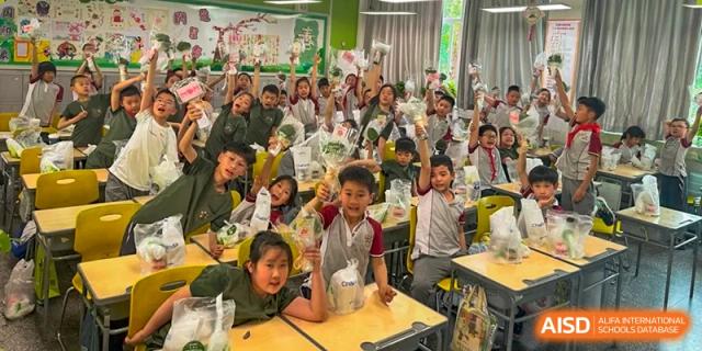 A large group of excited students smiling in a classroom at Weiming School Chengdu Qingbaijiang.