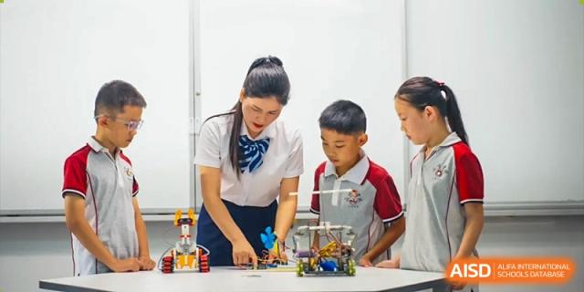 A teacher helping students with a science project at Weiming School Chengdu Qingbaijiang.