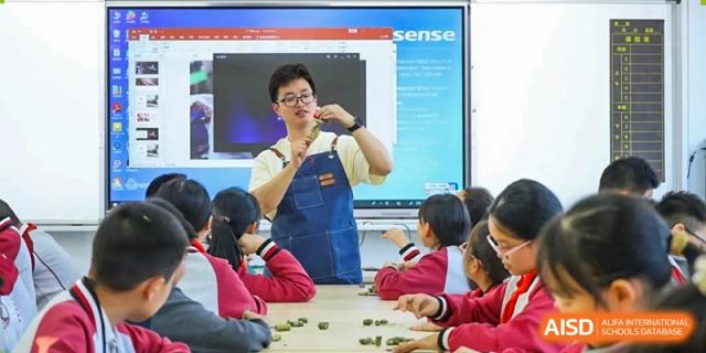 A teacher demonstrating an experiment to students at Weiming School Chengdu Qingbaijiang.