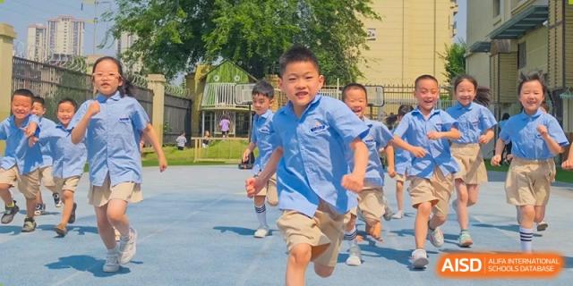 Weiming School Chengdu Qingbaijiang students running during a race on a sports field.