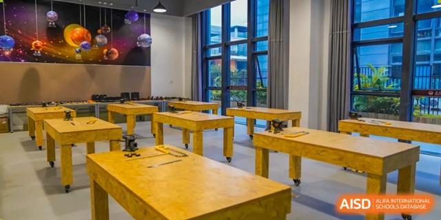 A close-up view of yellow work tables with wheels in a workshop or laboratory setting at Weiming School Shenzhen Nanshan.
