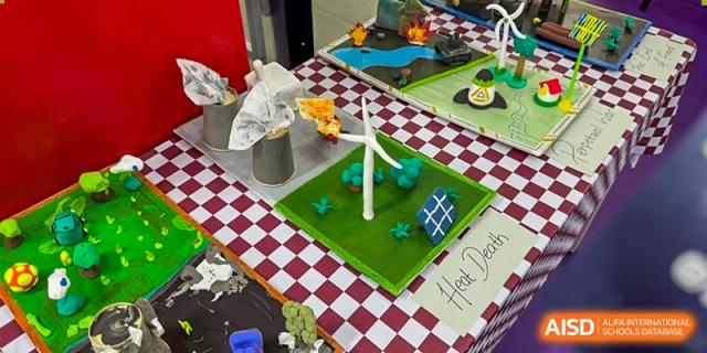 A student-made model project on a table, including a miniature wind turbine and a solar panel, showcasing a science project at Weiming School Shenzhen Nanshan.