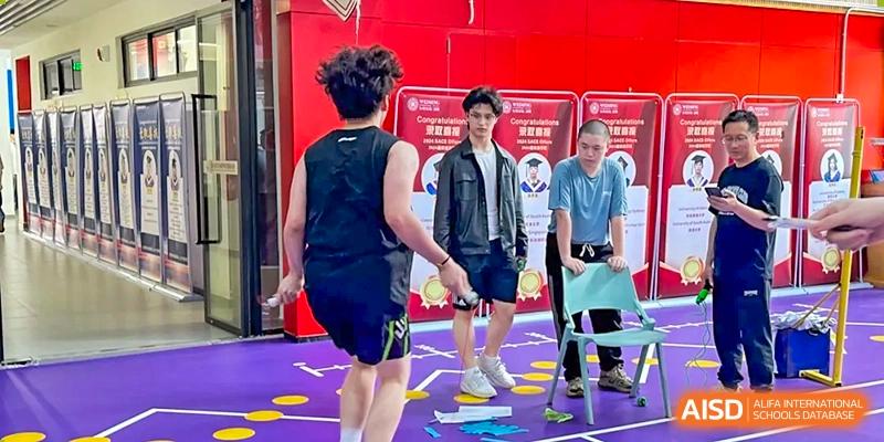 A student in black athletic wear walking on a brightly colored purple and yellow indoor sports floor or activity area at Weiming School Shenzhen Nanshan.