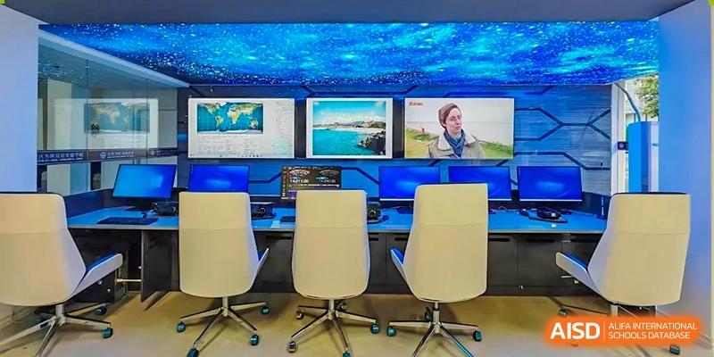 A control room or media center setup with multiple monitors displaying content, and three office chairs, at Weiming School Shenzhen Nanshan.