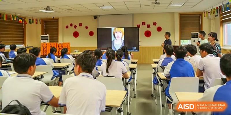 Students in a classroom watching a lesson or video on a large screen at Wenzhou No.21 Middle School.