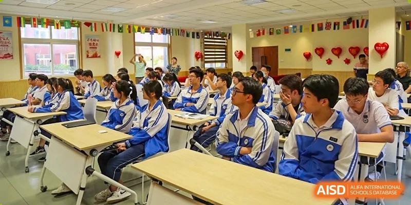 Classroom of students seated at wooden desks and engaged in a lesson at Wenzhou No.21 Middle School.