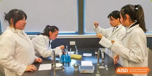 Student conducts a science experiment at a lab bench with glassware at Wenzhou No.21 Middle School.