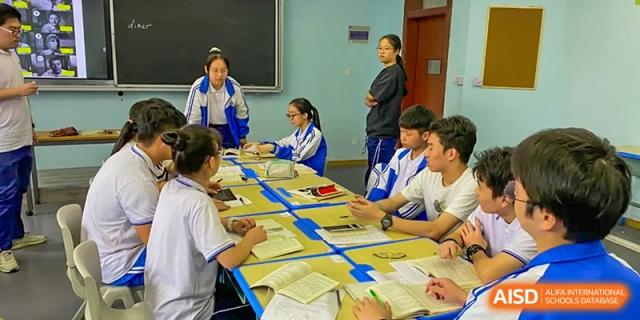 Students working in small groups during a discussion and activity in a classroom at Wenzhou No.21 Middle School.