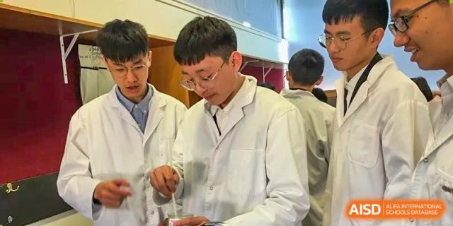 Male students in lab coats conducting an experiment in the science lab at Wenzhou No.21 Middle School.