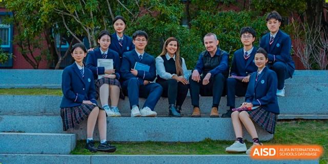 Group of students and an adult sitting outdoors on steps at Wenzhou No.21 Middle School.