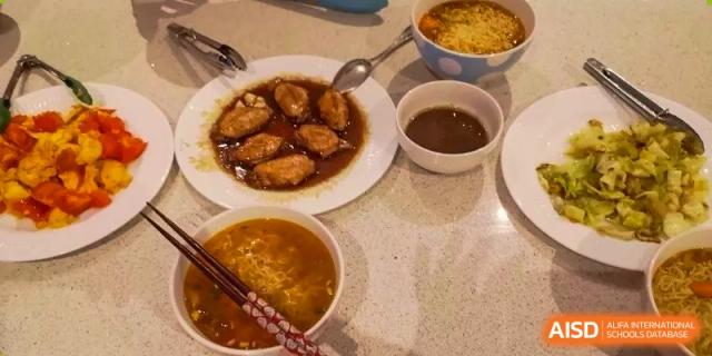 Plates of savory food including chicken wings and soup, the result of a cooking class at Wenzhou No.21 Middle School.