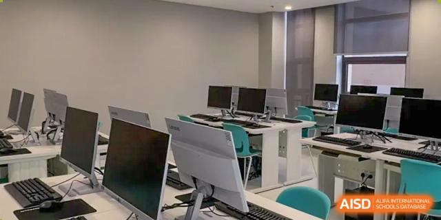 A dedicated computer lab with rows of monitors and modern computers for student use at Wuhan Optics Valley ULINK School.