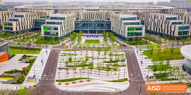 An aerial view looking down at the landscaped green spaces and courtyards of the modern campus buildings at Wuhan Optics Valley ULINK School.