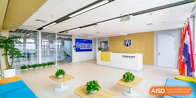 A bright, modern school reception or common area with light-colored walls and yellow accents at Wuhan Optics Valley ULINK School.