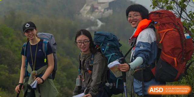 A student wearing a backpack and smiling while hiking outdoors, looking happy and adventurous, at Wuxi Dipont School of Arts and Science.