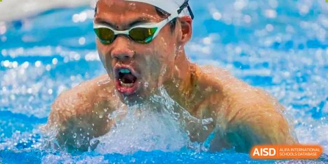 A close-up shot of a student emerging from the water while swimming, with a splash around their face, at Wuxi Dipont School of Arts and Science.