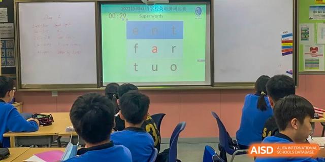 Students watching a lesson on a screen with English words in a classroom at Wuxi United International School.