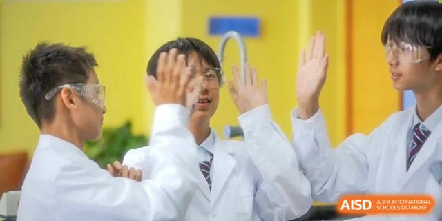 Students in lab coats during a science lesson, one looking through a magnifying glass at Wuxi United International School.