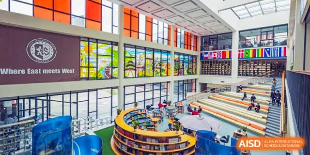 Interior view of the multi-story library and media center with circular bookshelves at Wuxi United International School.