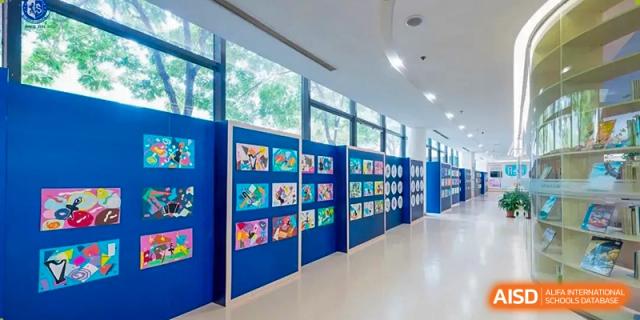 Long school hallway with student artwork displayed on blue boards at Wuxi United International School.