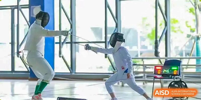 Student fencer in full gear practicing or competing in a lunge position at Wuxi United International School.