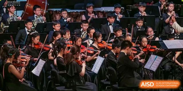 Students performing as part of a large classical orchestra at Wuxi United International School.