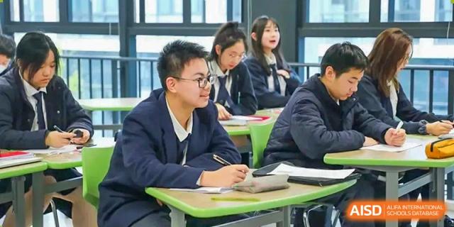 Two students from Wycombe Abbey School Nanjing sitting at a desk and working together.