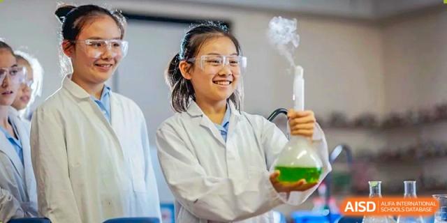 A student from Wycombe Abbey School Nanjing wearing safety goggles and smiling in a lab.