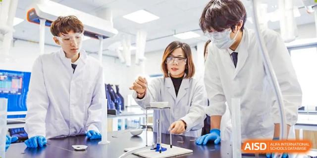 A teacher from Wycombe Abbey School Nanjing demonstrating a science experiment to students in a lab.