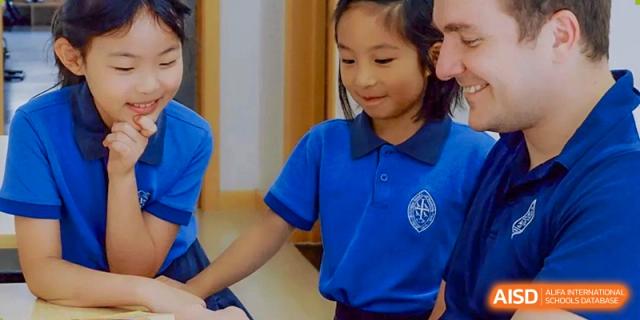 A young girl from Wycombe Abbey School Nanjing smiling and holding a folder.