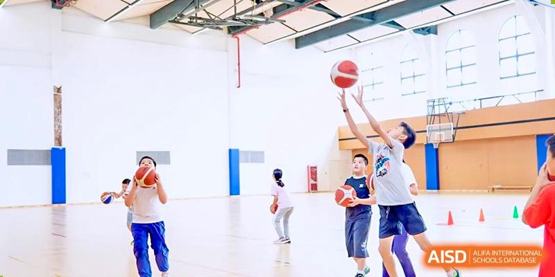 Students from Wycombe Abbey School Nanjing playing basketball in a gym.