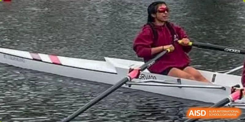 A student from Wycombe Abbey School Nanjing rowing in a boat on the water.
