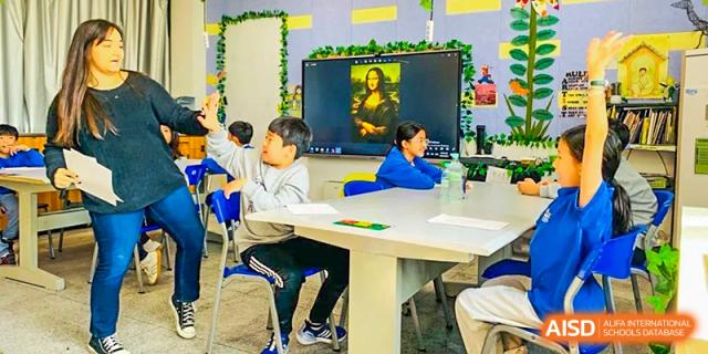 Xi'an International School students in a bright classroom looking at an interactive screen displaying a picture of the Mona Lisa.