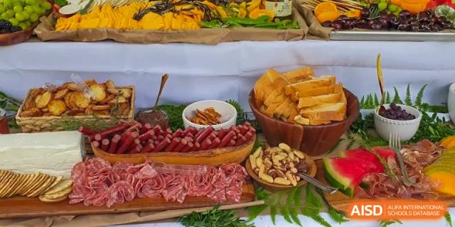 A buffet table at Xi'an International School featuring a spread of meats, cheeses, and crackers for an event.