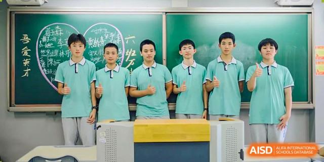Students from Xiamen Yingcai school standing in front of a blackboard in a classroom.