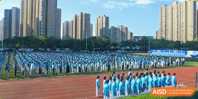 A large group of Xiamen Yingcai school students gathered on a field for an event.