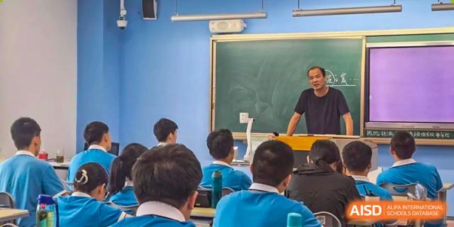 A teacher from Xiamen Yingcai school giving a lecture to a classroom of students.