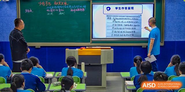A blackboard in a classroom at Xiamen Yingcai school with Chinese writing on it.