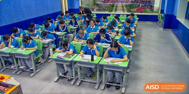 Students from Xiamen Yingcai school working at their desks in a classroom.