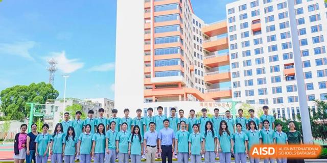 A group photo of students and teachers from Xiamen Yingcai school outdoors.
