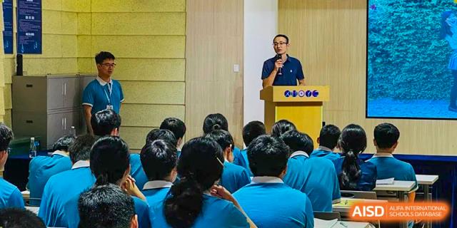 A speaker from Xiamen Yingcai school giving a lecture to a group of students.
