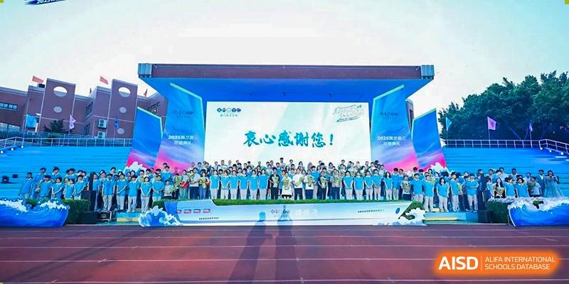 A large group of students and teachers from Xiamen Yingcai school gathered on a track for a group photo.