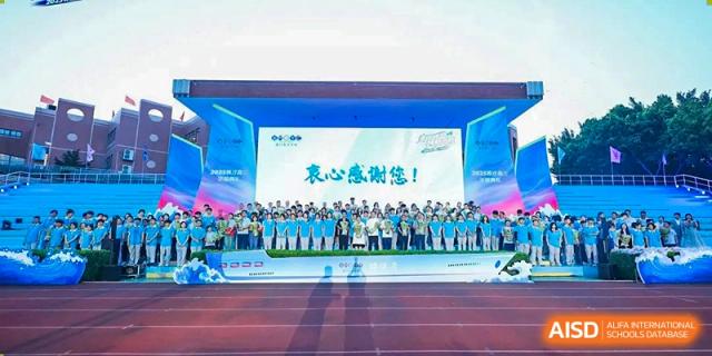 A large group of students and teachers from Xiamen Yingcai school gathered on a track for a group photo.