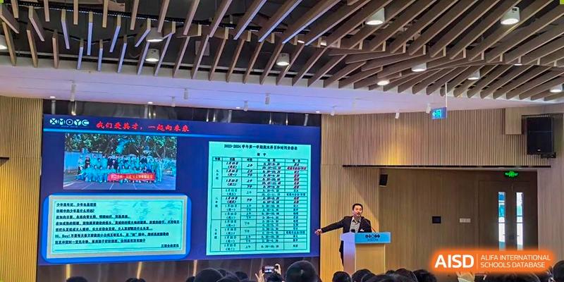 A teacher from Xiamen Yingcai school giving a presentation in a lecture hall.