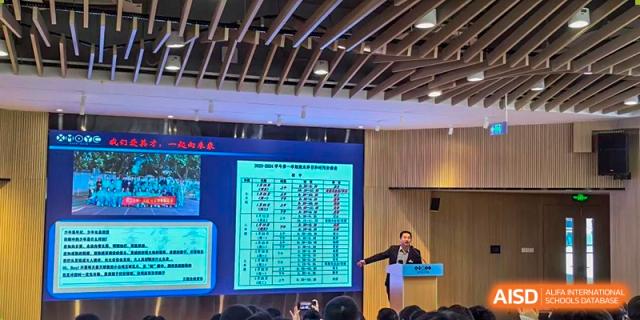 A teacher from Xiamen Yingcai school giving a presentation in a lecture hall.