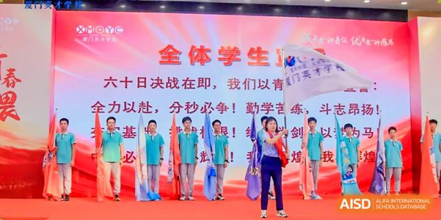 Students from Xiamen Yingcai school holding a banner at a sports event.