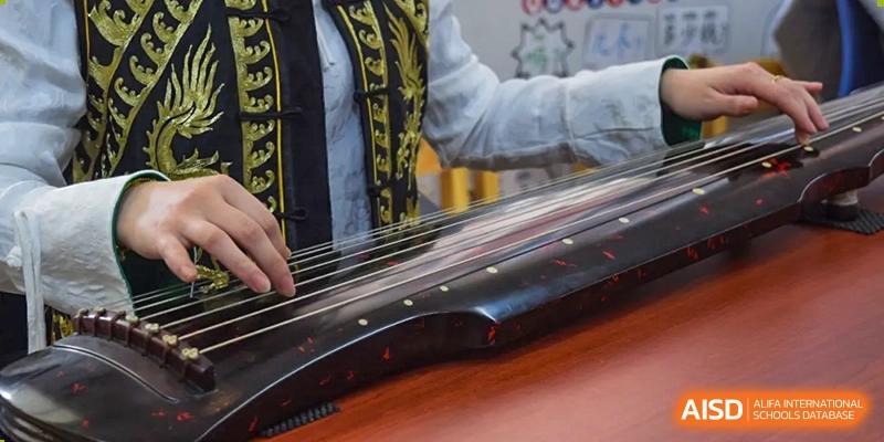 A close-up view of the strings and surface of a traditional Chinese musical instrument, likely used by students at Yantai Huasheng International School (YHIS).