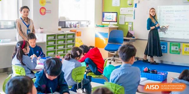 Students working on a project with a teacher in a classroom at Yew Chung International School of Shanghai.